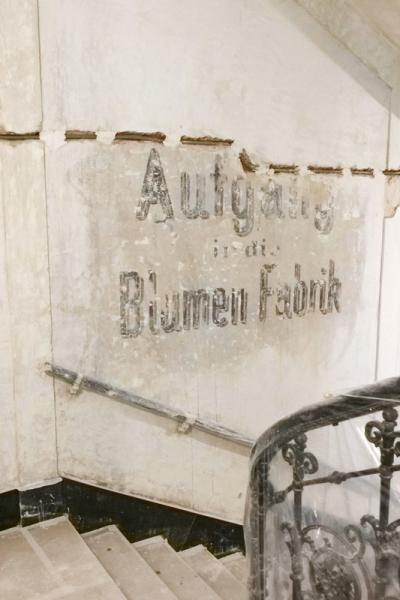Stiegenaufgang in der Neustiftgasse 36, wo der Schriftzug "Aufgang in die Blumenfabrik" auf der Wand aus dem 19. Jahrhundert freigelegt wurde.