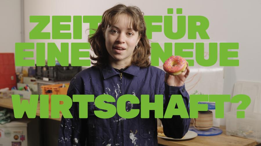 Junge Frau im blauen Arbeitsmantel hält Donut in der Hand und schaut in die Kamera. Um sie herum der Schriftzug: Zeit für eine neue Wirtschaft?