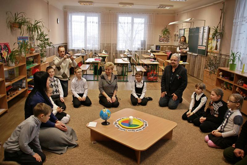 Kinder sitzen im Kreis um Geburtstag zu feiern.