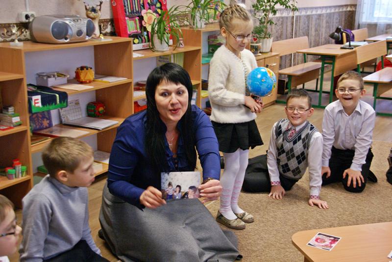 Kinder sitzen im Kreis für Montessori-Geburtstagsfeier.