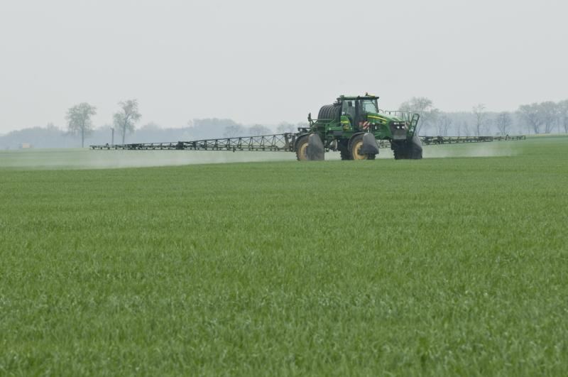 Traktor der Pestizide am Feld ausbringt