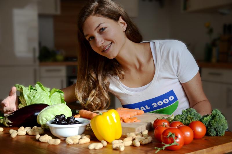 Frau kocht mit Gemüse