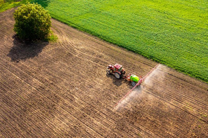 Traktor sprüht Pestizide, Aufnahme von oben als Luftbild