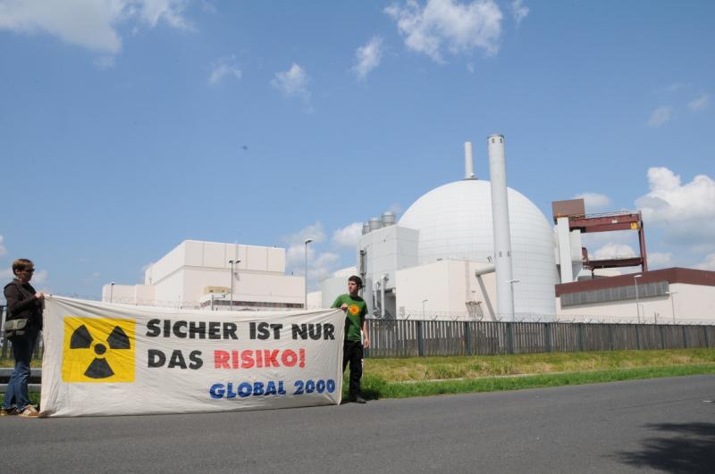 Aktivisten von GLOBAL 2000 stehen vor dem AKW Brokdorf mit großem Banner auf dem steht "Sicher ist nur das Risiko"