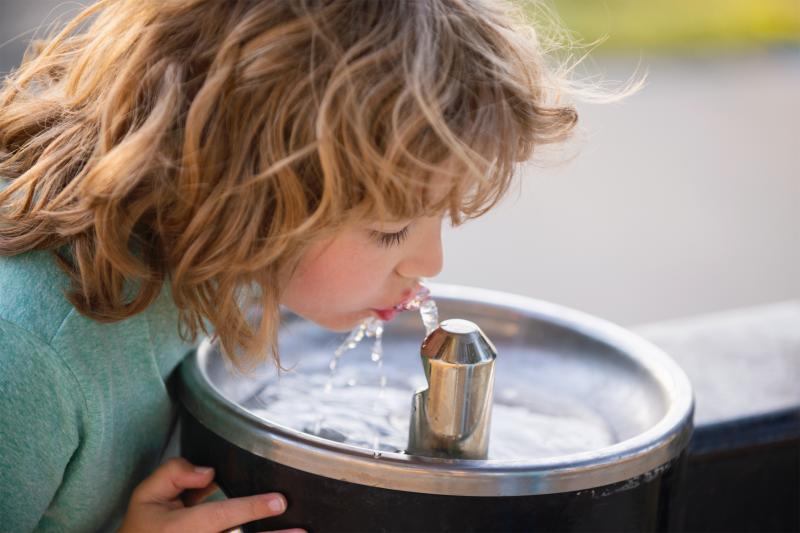 Kind trinkt aus Trinkwasserspender