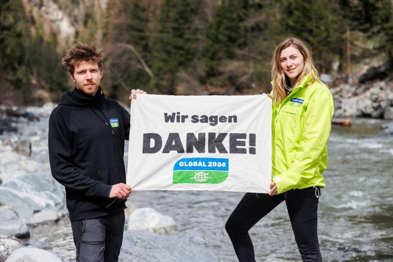 Mitarbeiter und Mitarbeiterin von GLOBAL 2000 halten Banner mit Wir sagen Danke