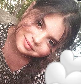 Mädchen mit Schwarz weißem Shirt und Braunen Haaren lächelt. 