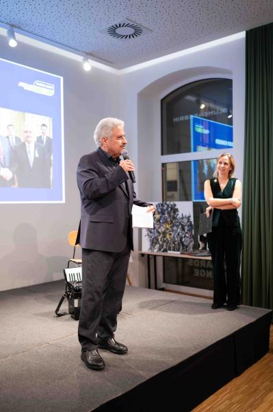 Vortrag Christoph Otto mit Mikrophon vor einer Präsentation