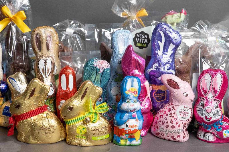 Viele Osterhasen stehen zusammen auf dunklem Hintergrund