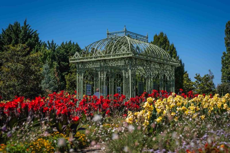 Pavillon inmitten von roten und gelben Blumen in den Blumengärten Hirschstetten