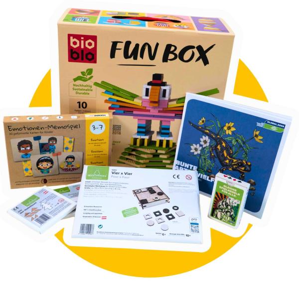 Mehrere Kinderspiele und Spielzeugverpackungen, darunter eine bunte "bio blo FUN BOX" mit einem Vogel aus Holzklötzen, ein Emotionen-Memospiel, ein Kartenspiel mit Salamander-Motiv und weitere Spielkartensets