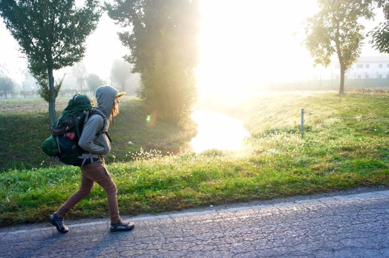 Weitwanderer auf Straße im Morgenlicht