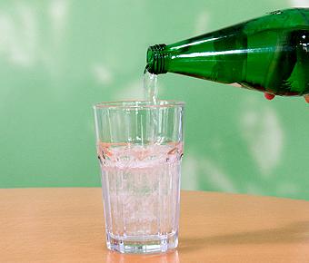 Mineralwasser wird in Wasserglas geschenkt