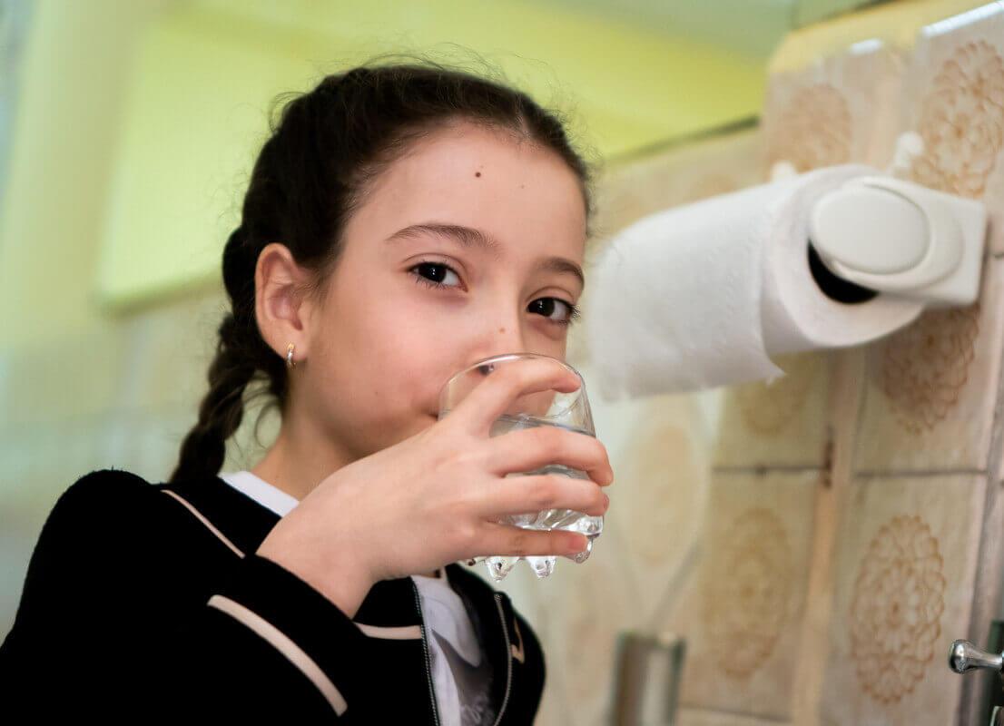 Kind mit frischem Trinkwasser