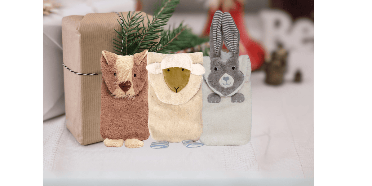 3 Wärmflaschen in Tierform vor weihnachtlichem Hintergrund