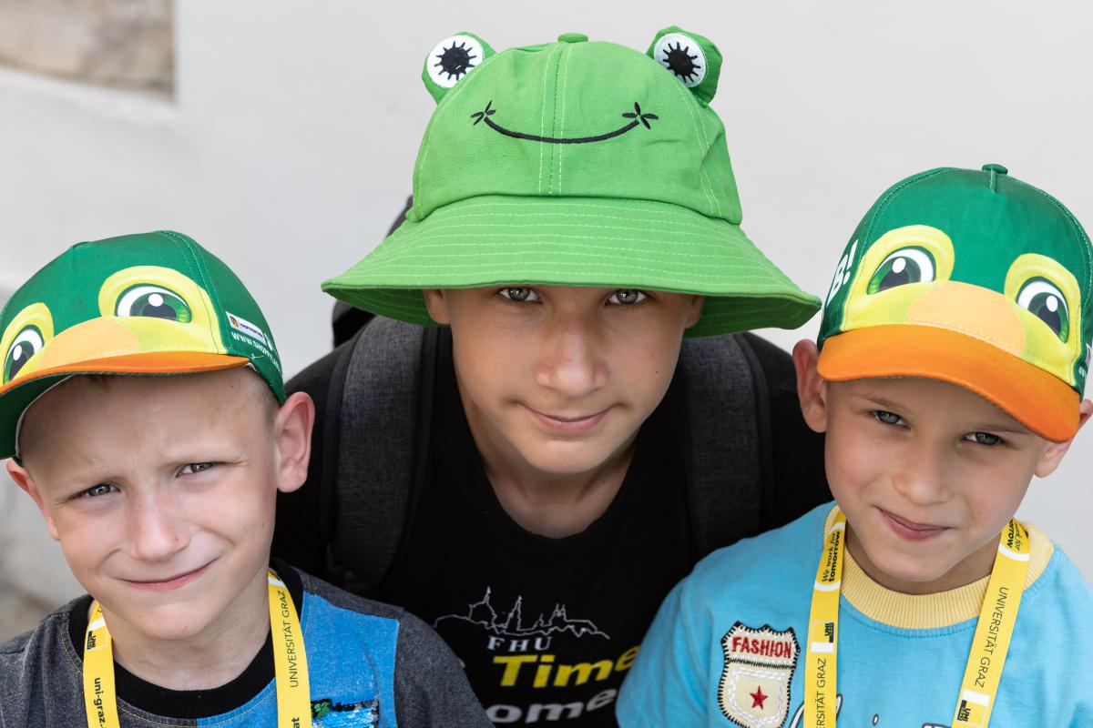 3 Buben mit Tiermützen schauen in die Kamera