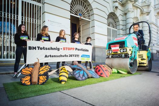 Aktivist:innen von GLOBAL 2000 mit Banner für Artenschutz und Insektenmodellen