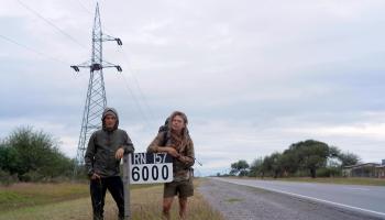 Zwei Wanderer stehen auf südamerikanischer Straße