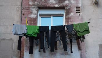 Wäscheleine mit bunter Wäsche vor einem Fenster