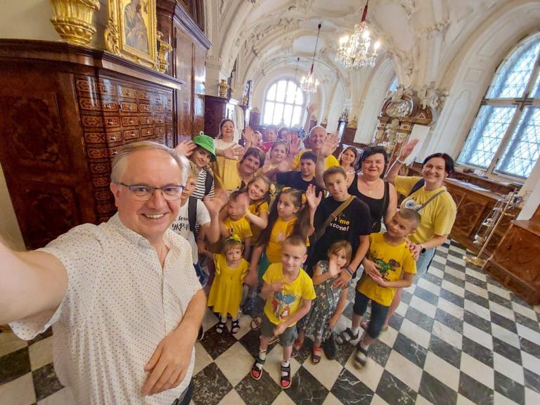 Mann im Vordergrund macht ein Selfie mit der Kindergruppe, die im Dom stehen