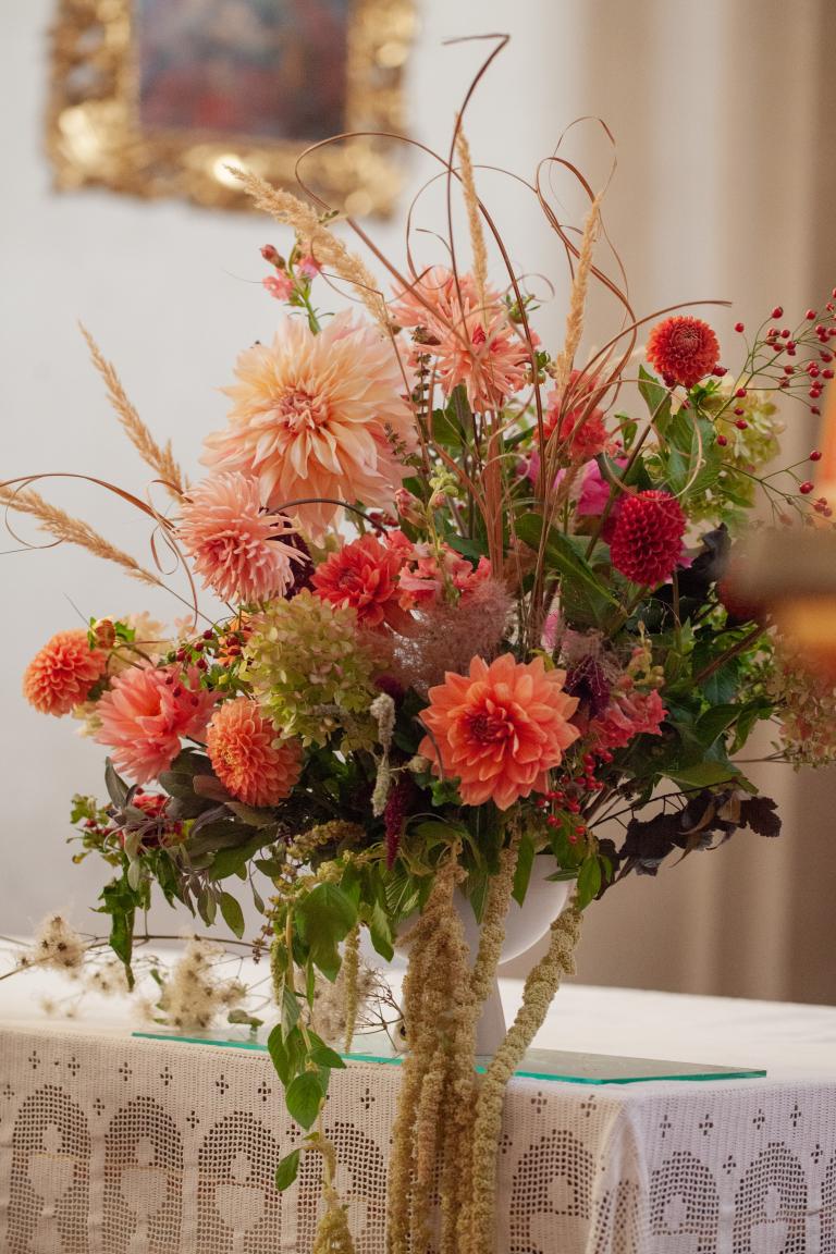 ein bunter Blumenstrauß auf einem Tisch mit Spitzendecke