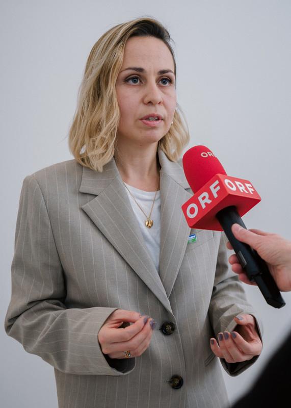 Juliana Matusova spricht in ein Mikrofon, dass das ORF Logo trägt