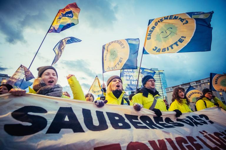 Aktivist:innen halten ein großes Banner mit der Aufschrift "Sauberes Gas?" bei einer Demo