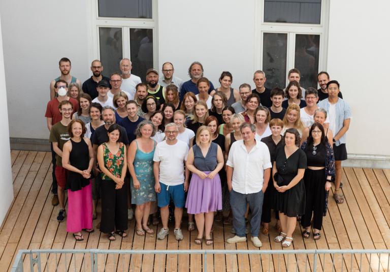 Ein Gruppenfoto von allen GLOBAL 2000 Mitarbeiter:innen auf der Terrasse