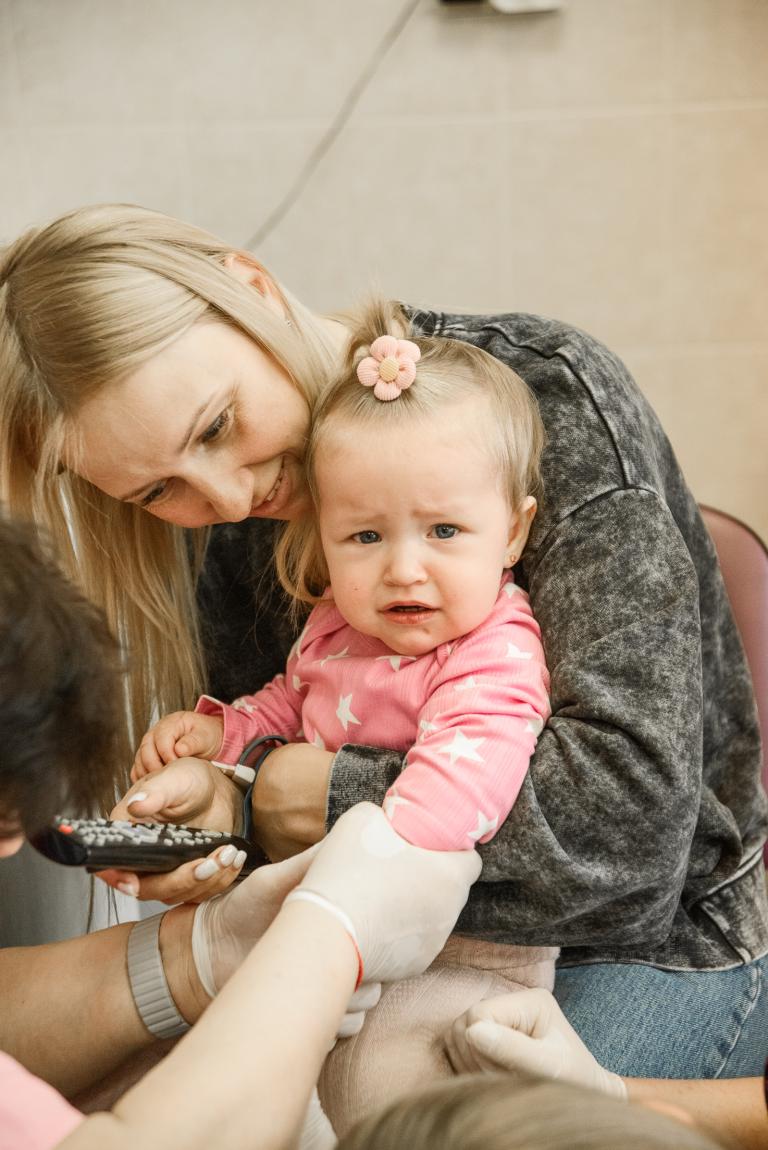 weinendes Kind im Arm der Mutter