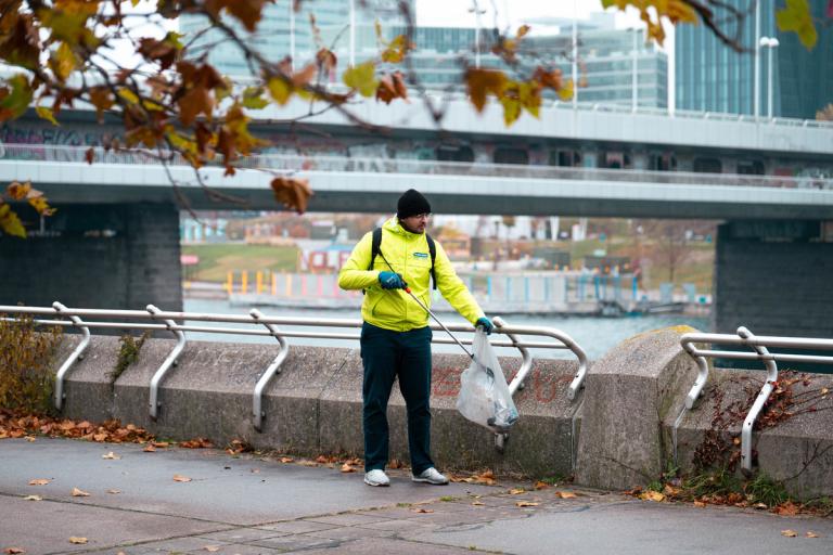 Mensch beim Müllsammeln auf der Donauinsel