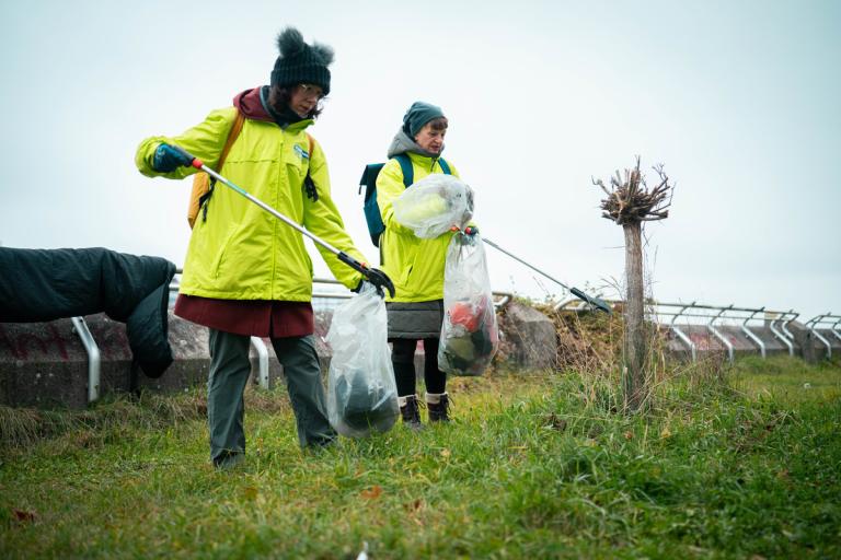 2 Frauen in GLOBAL 2000 Jacken beim Müllsammeln auf der Domauinsel