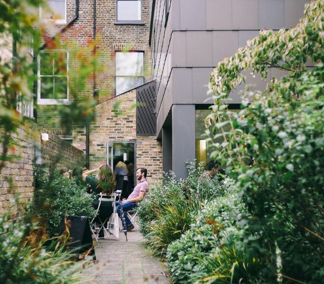 Was wäre, wenn wir anders leben würden? Menschen sitzen im Garten in der Stadt