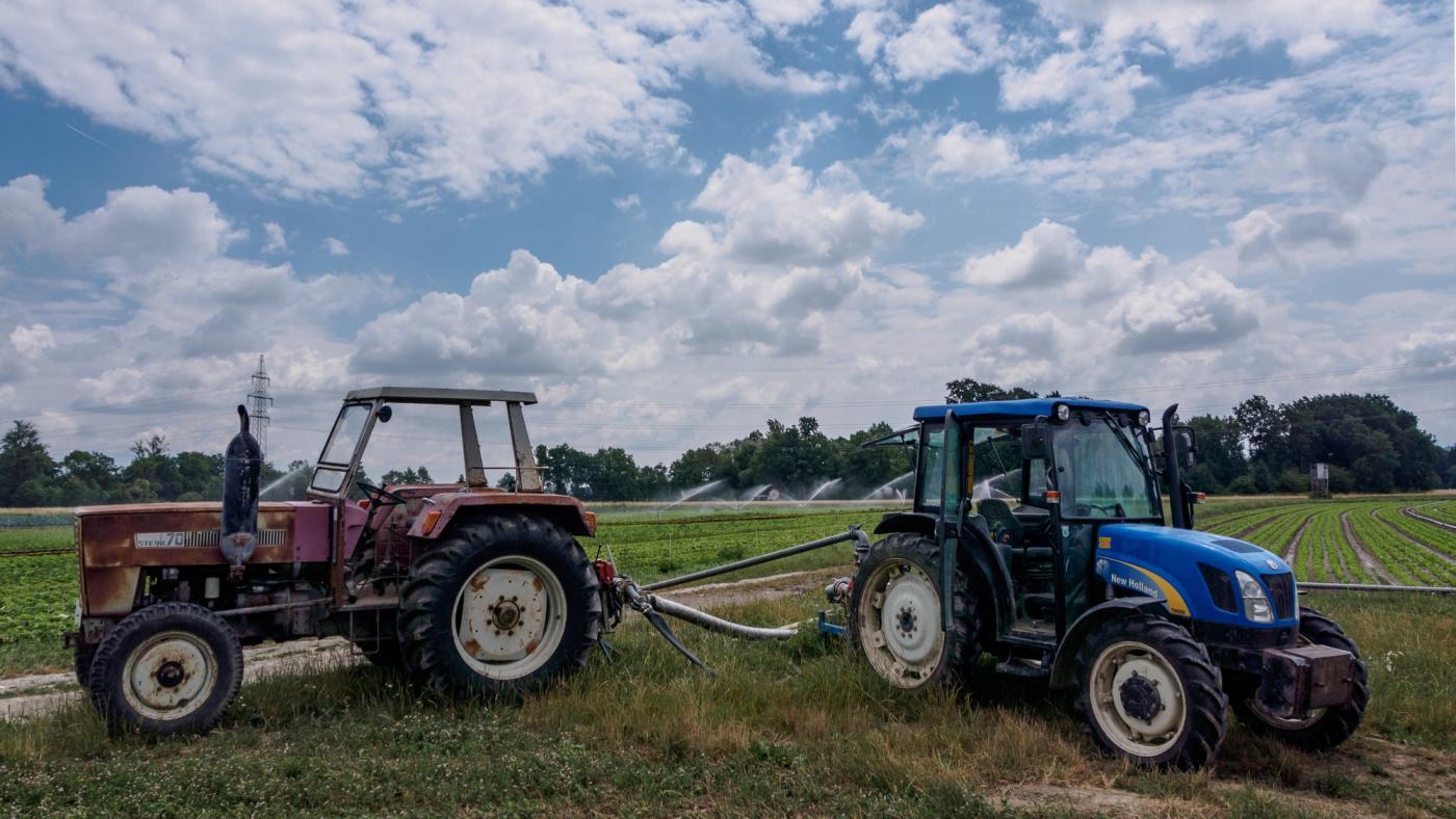 Ein alter und ein neuer Traktor stehen am Feld