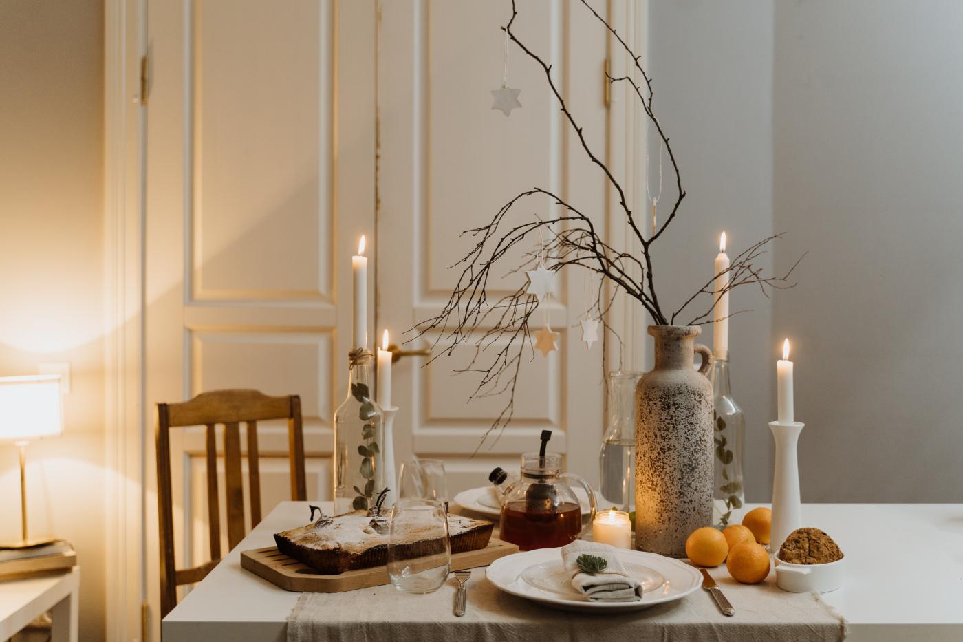 Gedeckter Tisch mit einer Vase, in der Zweige stehen