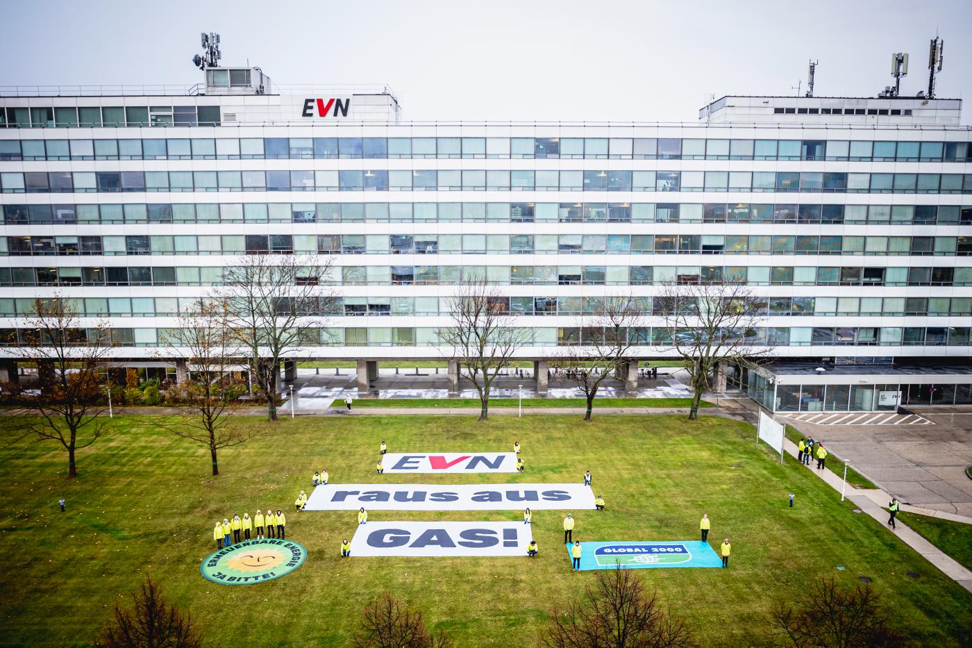 Banner mit Aufschrift "EVN – Raus aus Gas!" auf einer Wiese vor dem EVN-Hauptgebäude