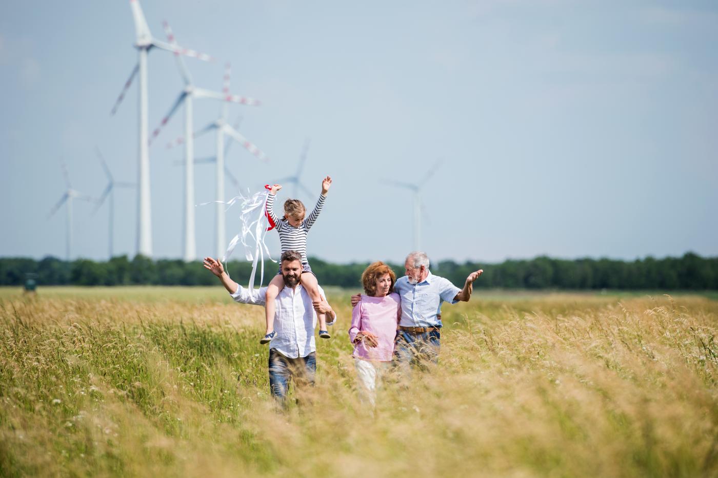 Familie auf einem Feld mit Windrädern