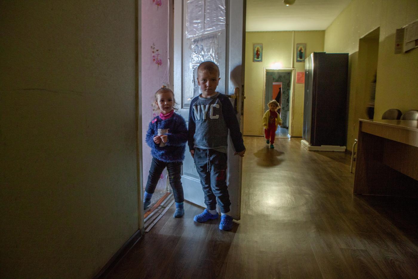 Zwei Kinder schauen neugierig aus dem Zimmer