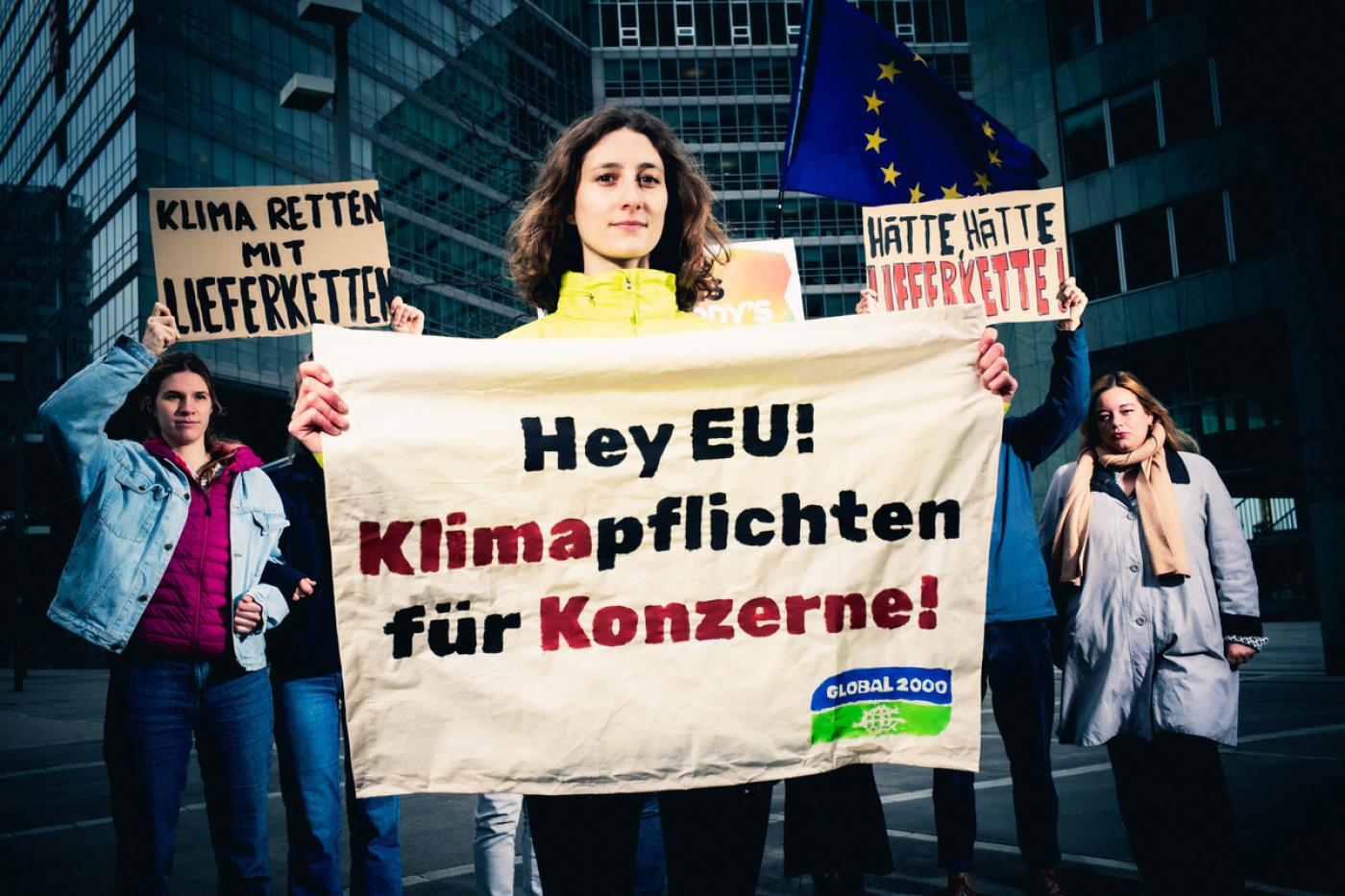 Anna Leitner hält Banner mit "Klimapflichten für Konzerne" in der Hand