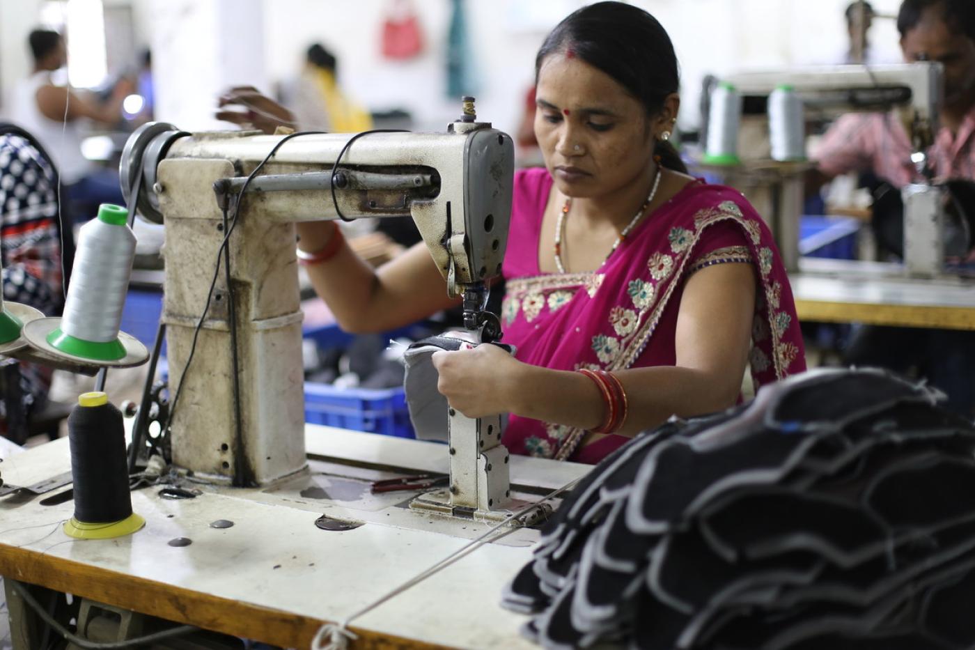 Indische Frau näht Schuhe an einer alten Nähmaschine