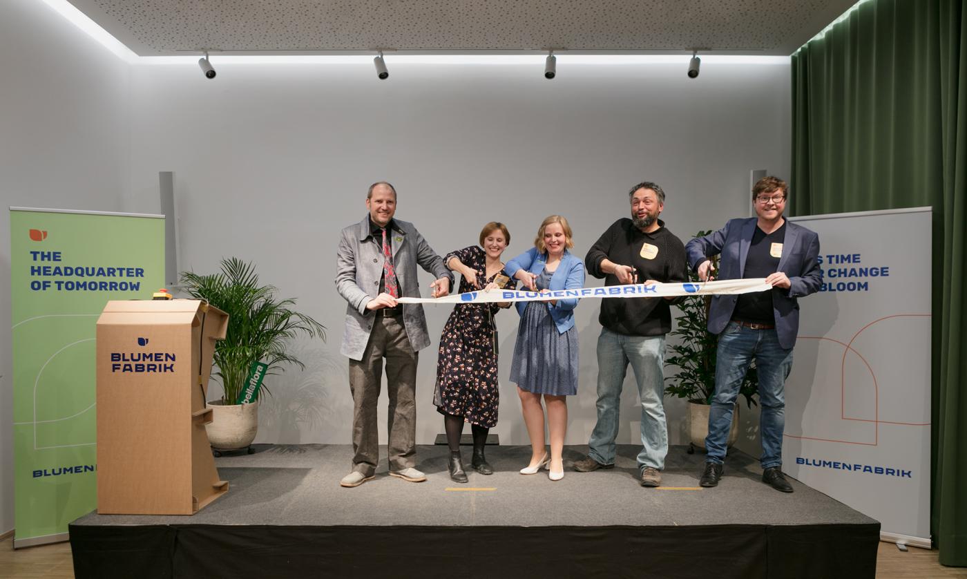 Rene Fischer, Mira Nograsek, Agnes Zauner, Martin Wittner und Nikolai Miron stehen auf der Bühne und schneiden ein Band zur Eröffnung der Blumenfabrik auseinander. 