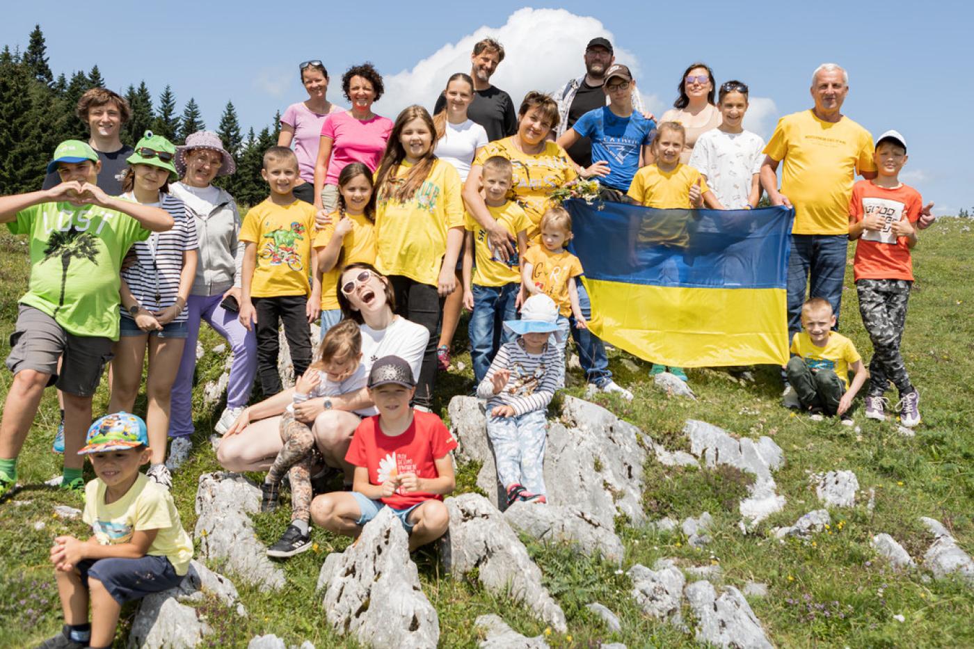 Gruppenfoto von den ukrainischen Kindern mit Betreuer:innen auf einer österreichischen Alm