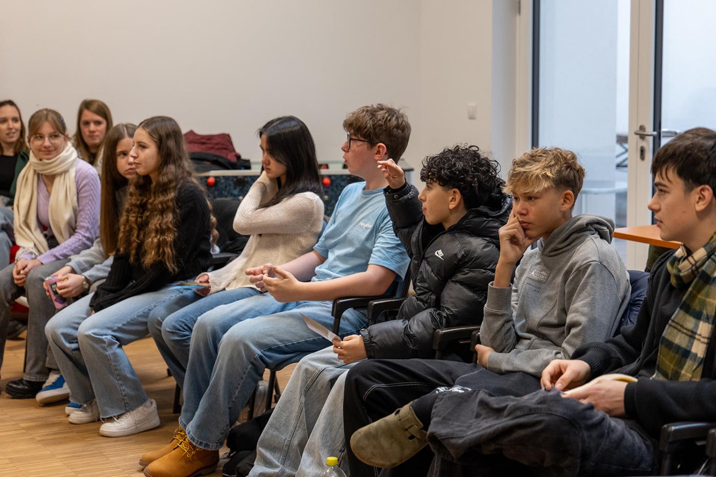 Jugendliche sitzen in einem Sesselkreis