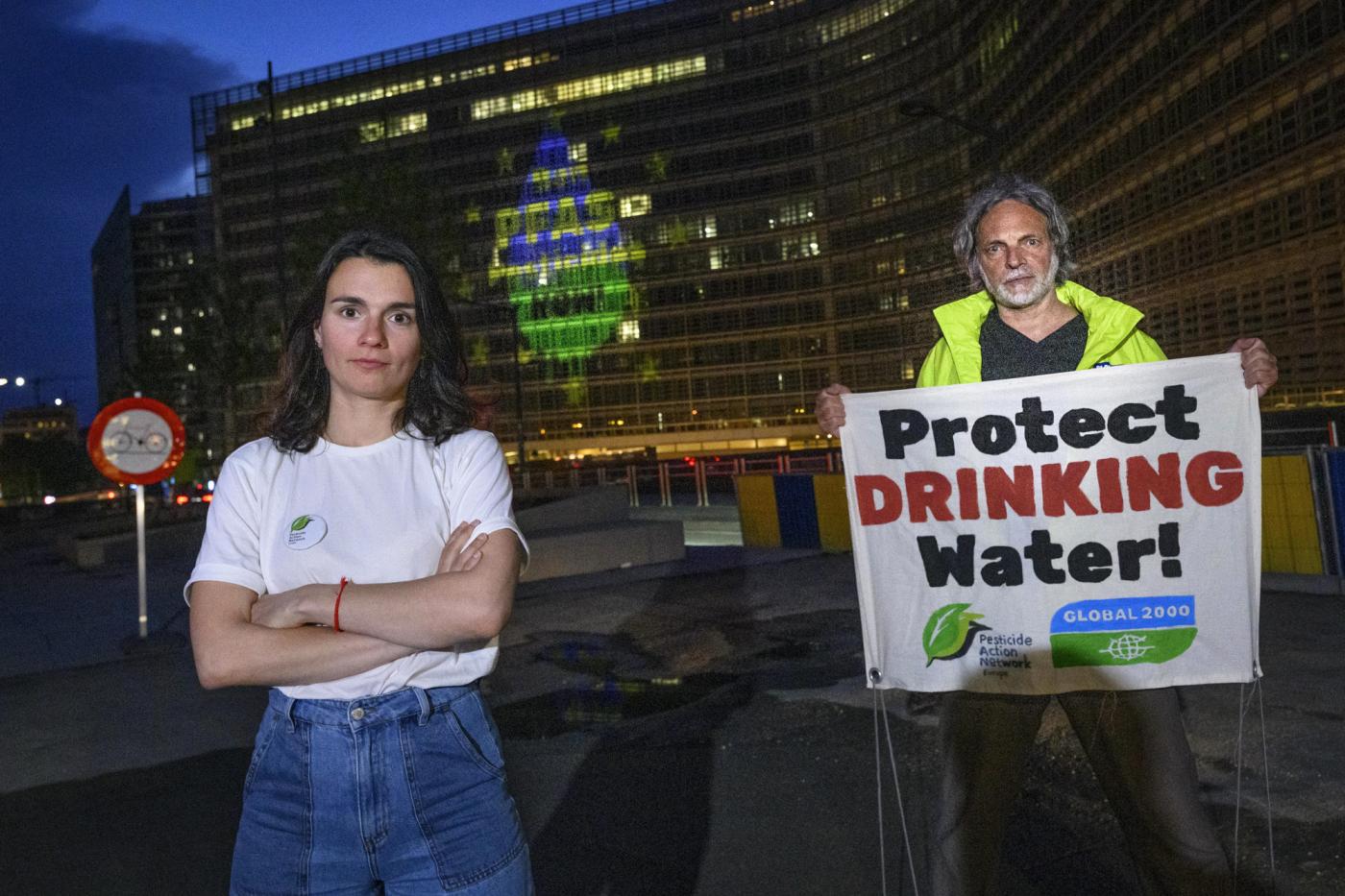2 Menschen stehen vor Gebäude mit einer Projektion