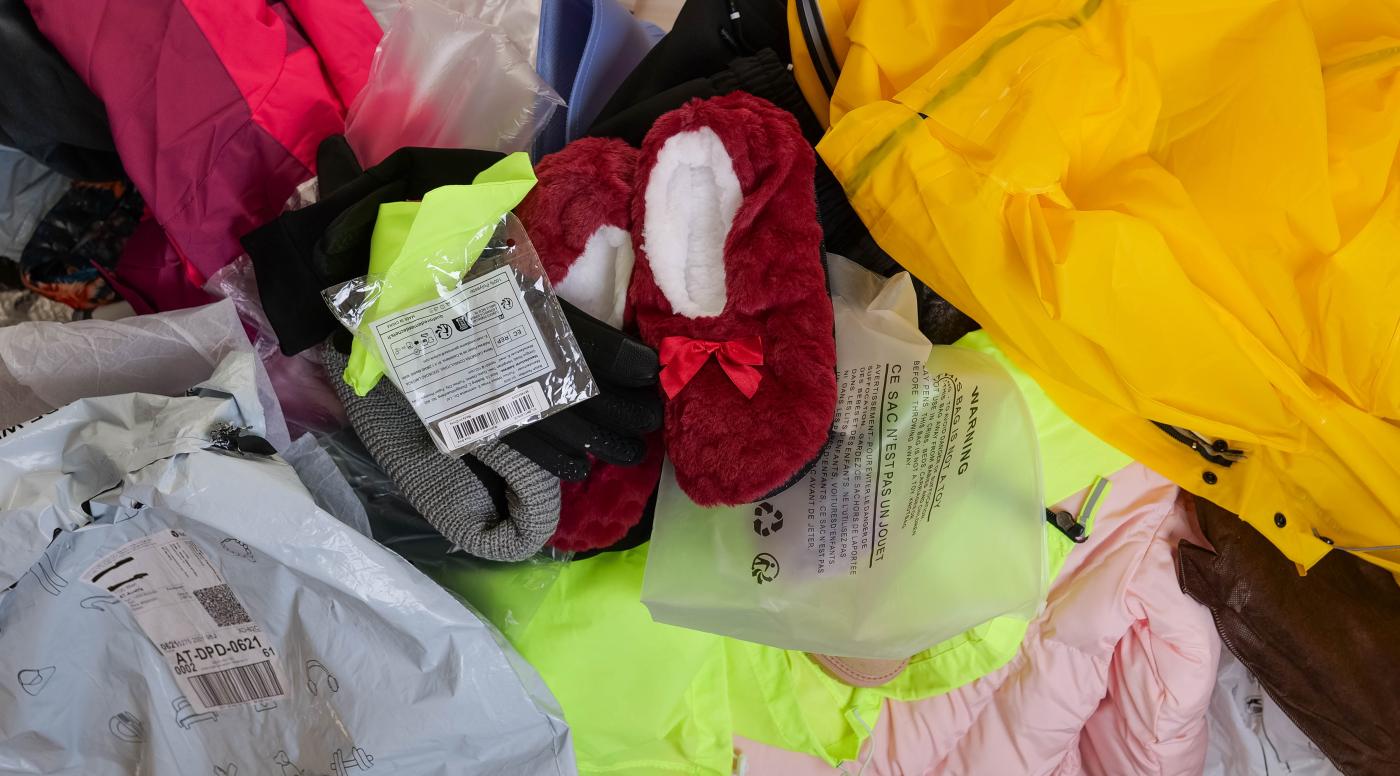 Kleidung und Verpackungsmüll von temu und shein auf einem Haufen