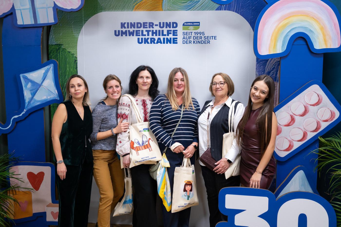 Sechs Frauen stehen vor 30 Jahre Jubiläumswand