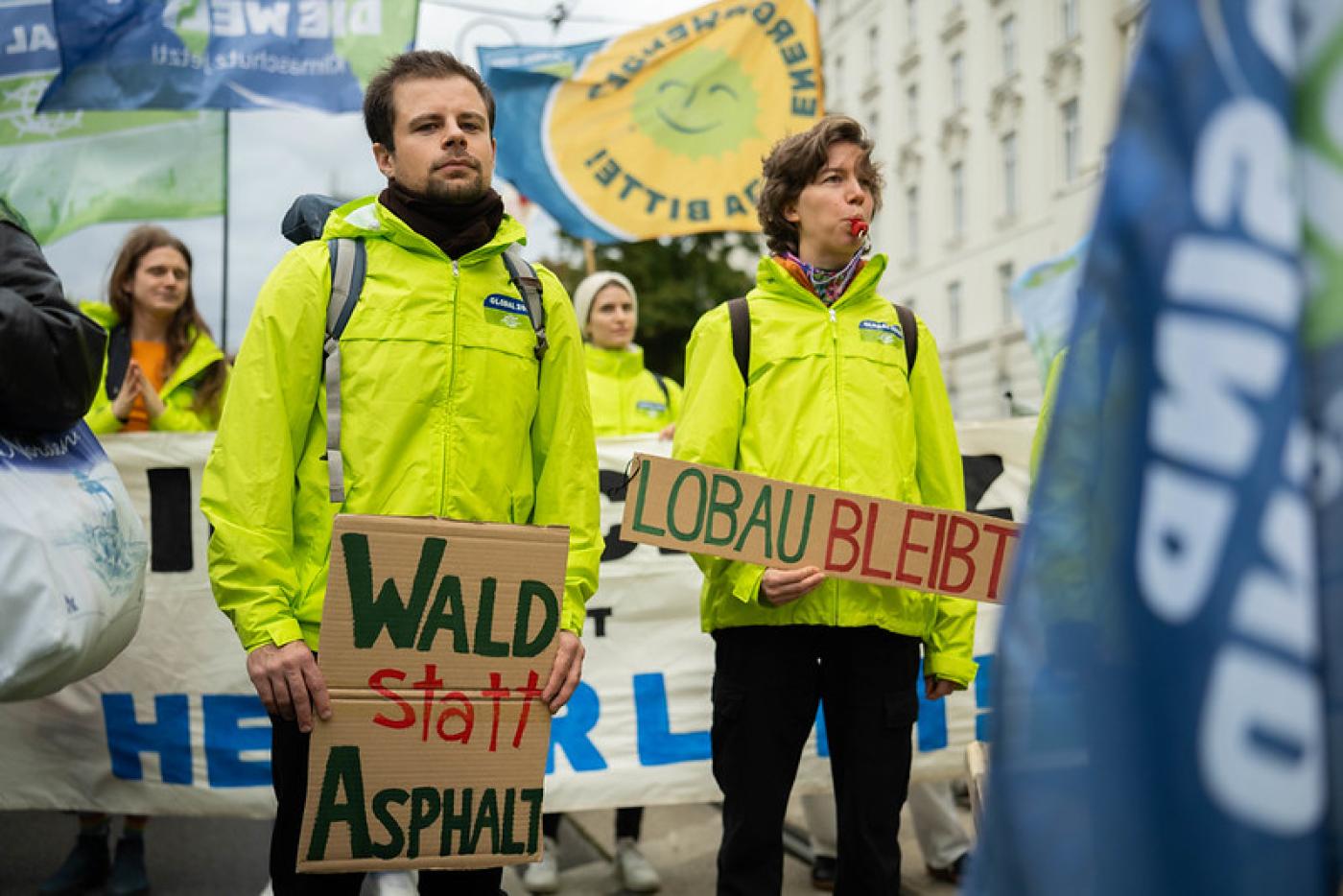 Aktivist:innen von GLOBAL 2000 mit Schildern Wald statt Asphalt und Lobau bleibt