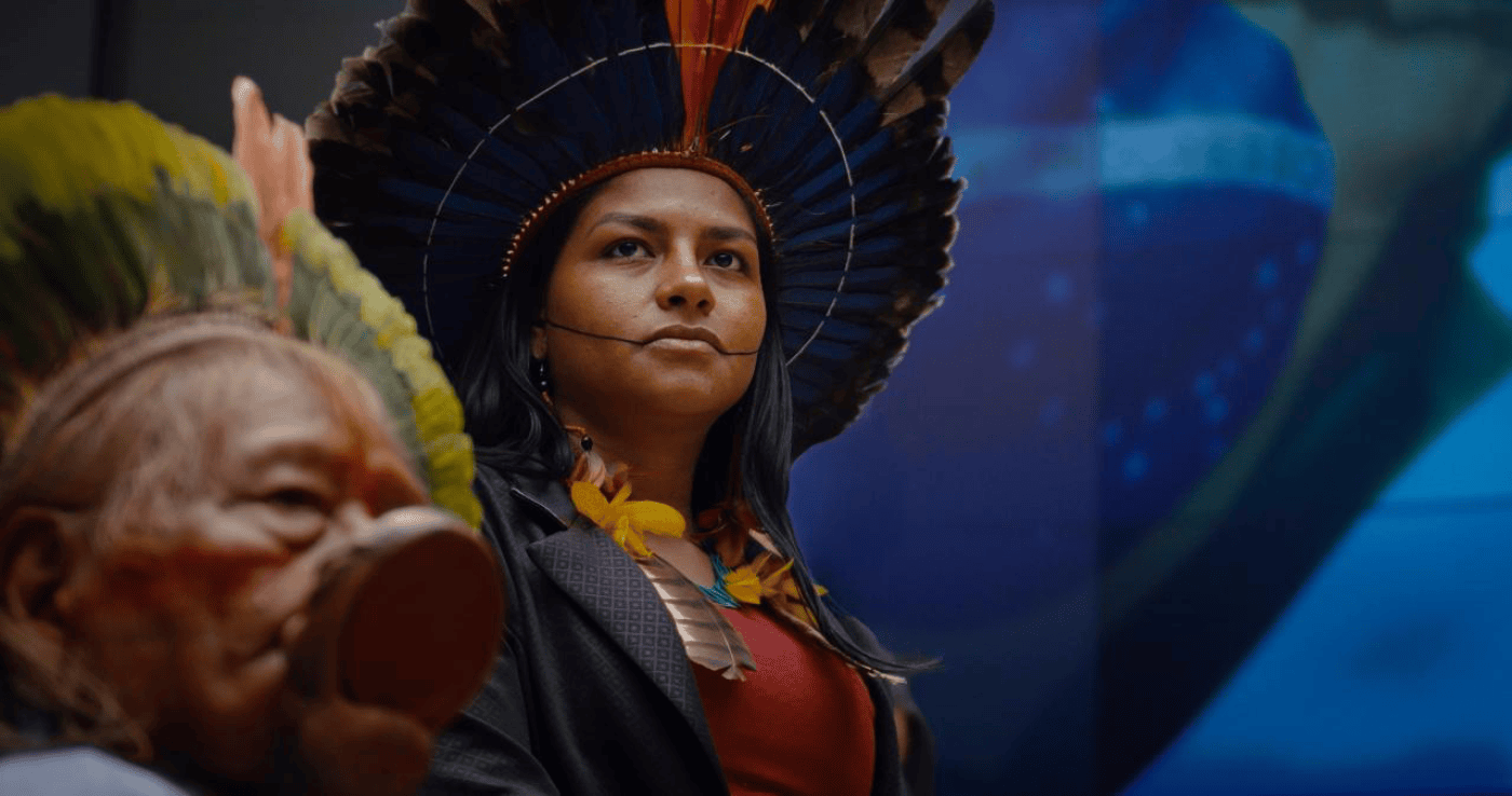 Filmsujet von Yanuni: Zwei Personen mit traditionellen Kopfschmuck und bunter Kleidung vor einem unscharfen Hintergrund