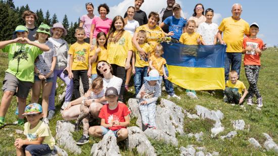 Gruppenfoto von den ukrainischen Kindern mit Betreuer:innen auf einer österreichischen Alm