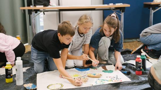 Schüler:innen beim Banner malen