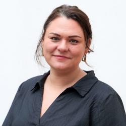 Christina Stampf mit dunklen zurückgebundenen Haaren und einer schwarzen Bluse